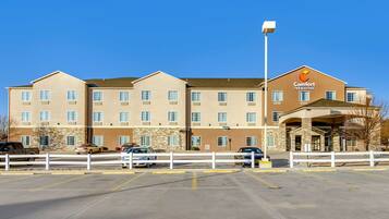 Een Comfort Inn & Suites hotel met een parkeerplaats ervoor.