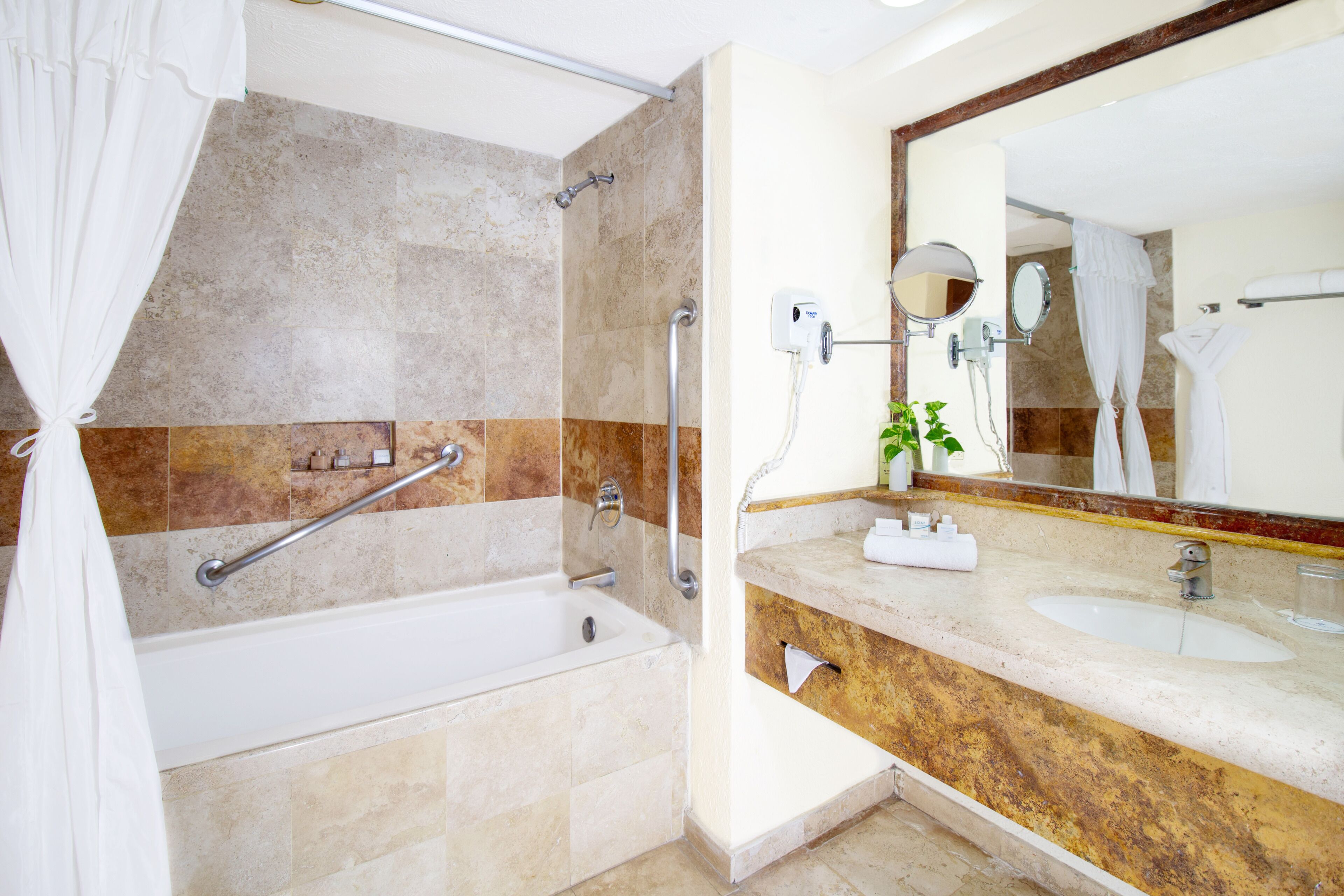 Une salle de bain moderne équipée d’une baignoire, d’une douche, d’un meuble-lavabo et d’un grand miroir.