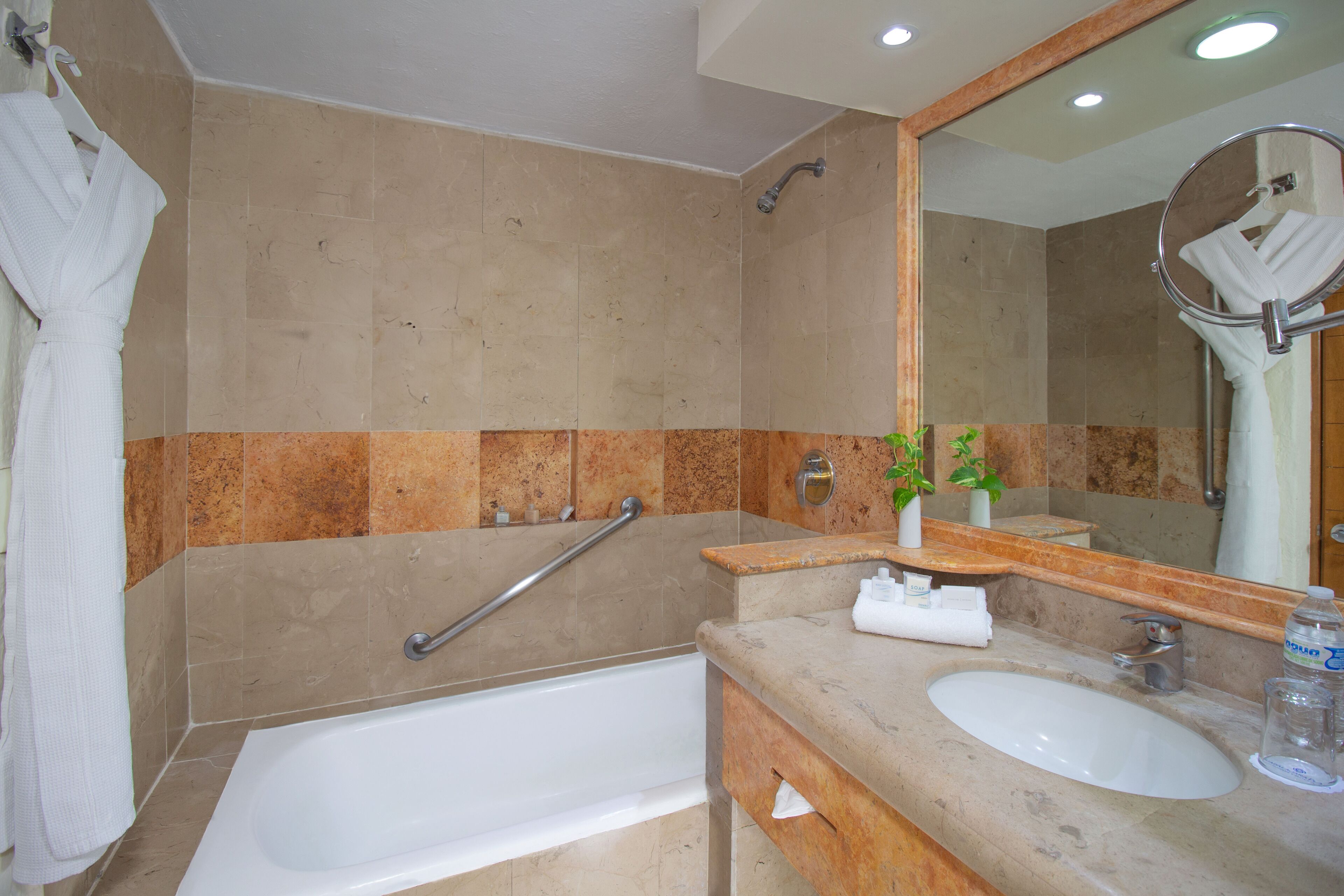 Une salle de bain avec une baignoire, un lavabo, un miroir et un porte-serviettes.