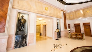 Eine Lobby mit Marmorböden, einem Empfangstresen und einer Statue.