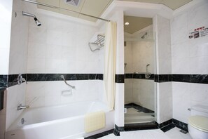 Un baño moderno con bañera, ducha e inodoro.