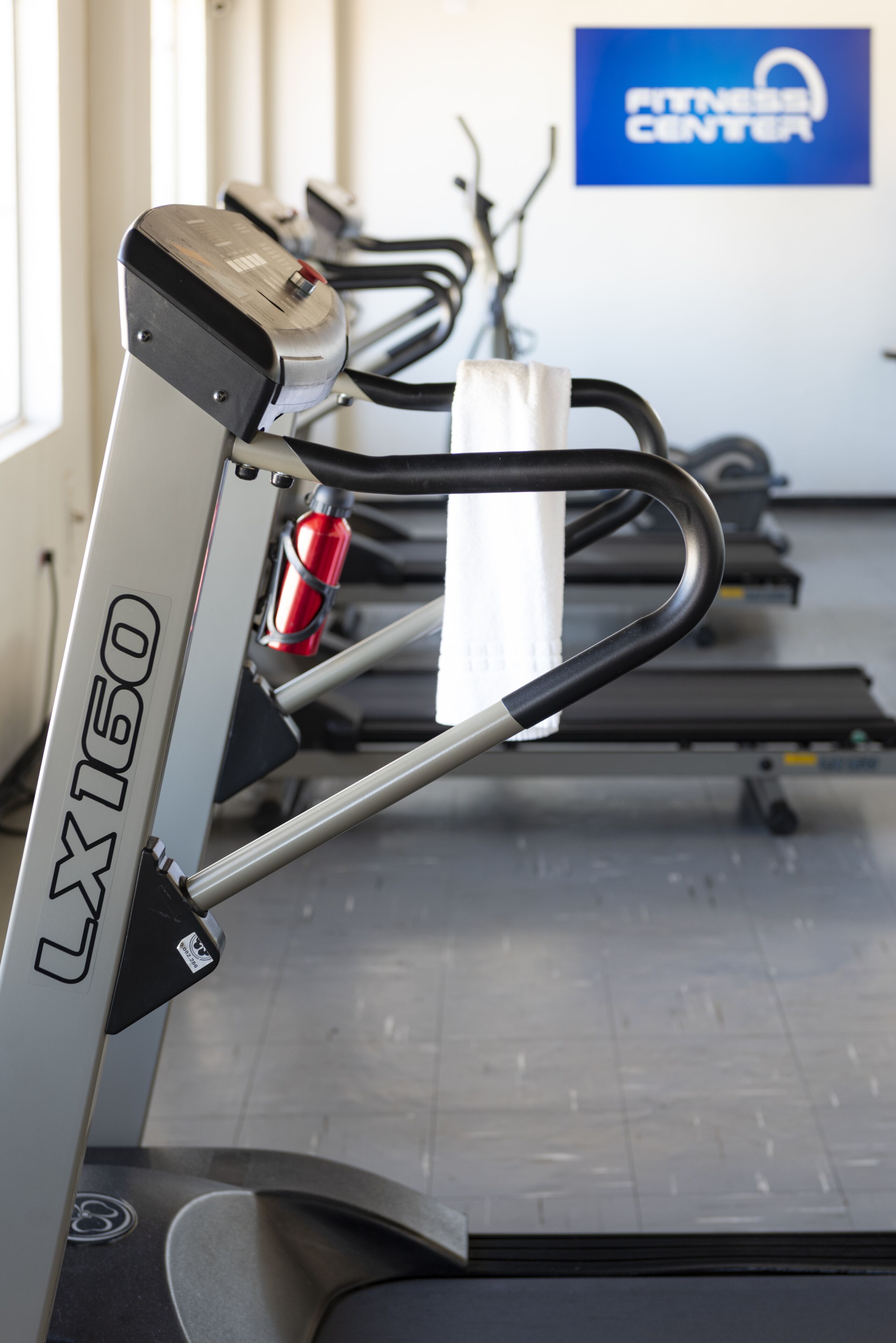 A stationary bike with the model number LX150 in a gym setting.