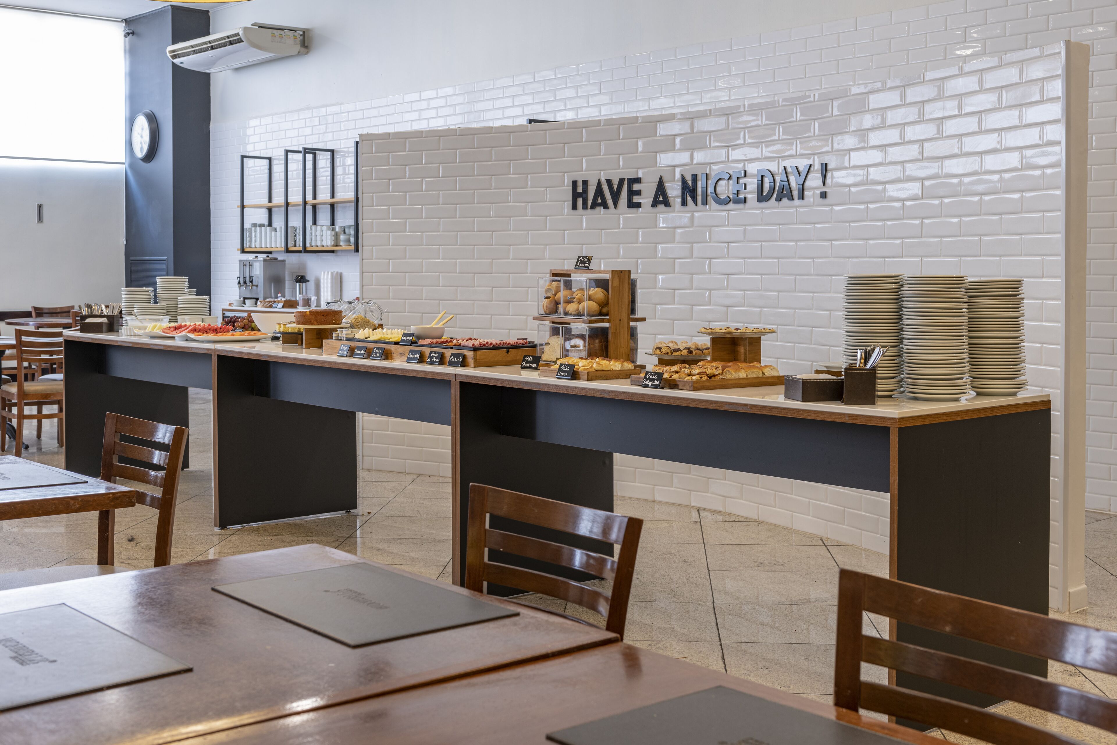 A breakfast bar with various food items and a sign saying "HAVE A NICE DAY!".