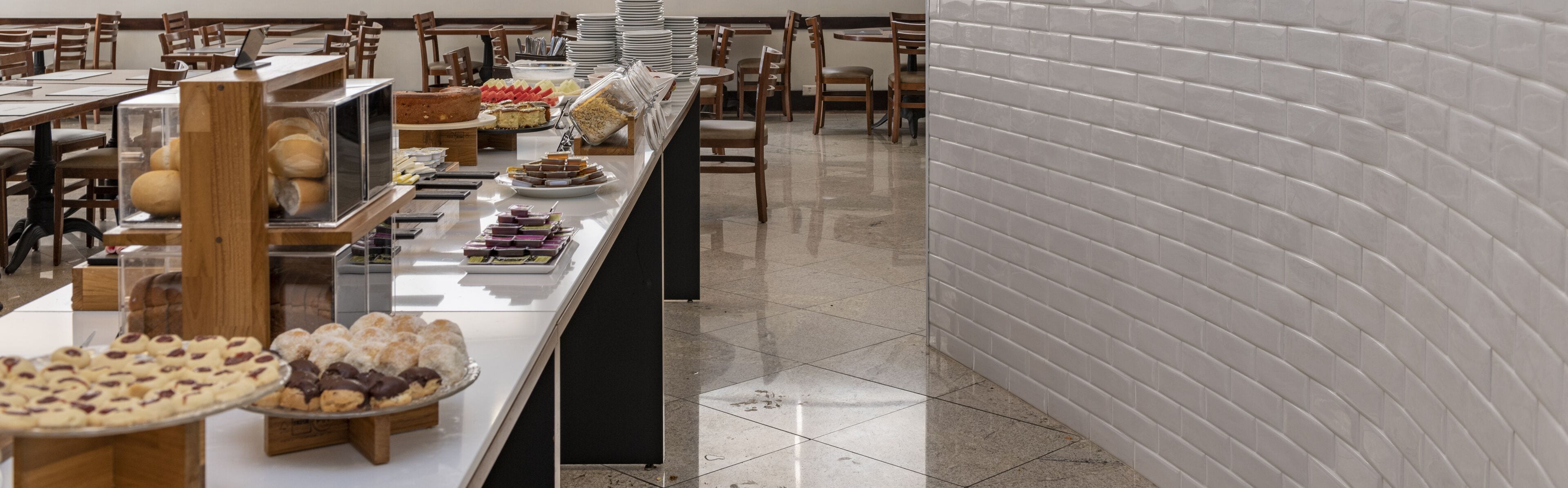 Disposição de buffet com diversos alimentos e um balcão longo.
