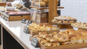 A bakery display with various baked goods like pastries and bread. - Monreale Express Ribeirão Preto (Ribeirão Preto)