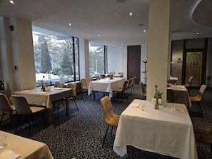 Un restaurant doté de nombreuses tables, de chaises et d’un sol recouvert de moquette.