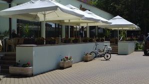 Ein Restaurant mit Außenbereich, Sonnenschirmen und Topfpflanzen.