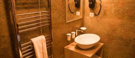 A bathroom with a towel rack, a sink, and a mirror.
