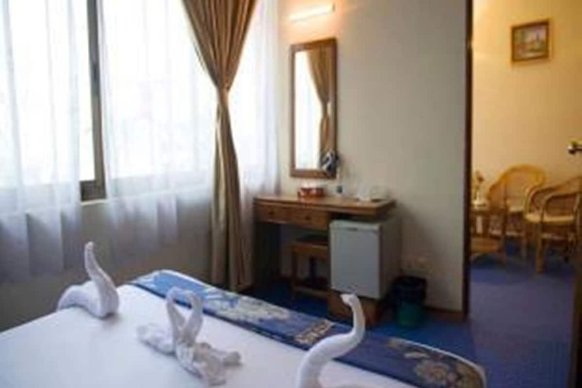 A hotel room with a bed, a desk, and a chair.