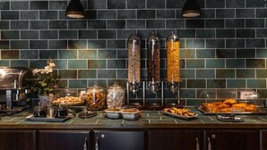 Una mesa de buffet con diferentes alimentos y una máquina de café.