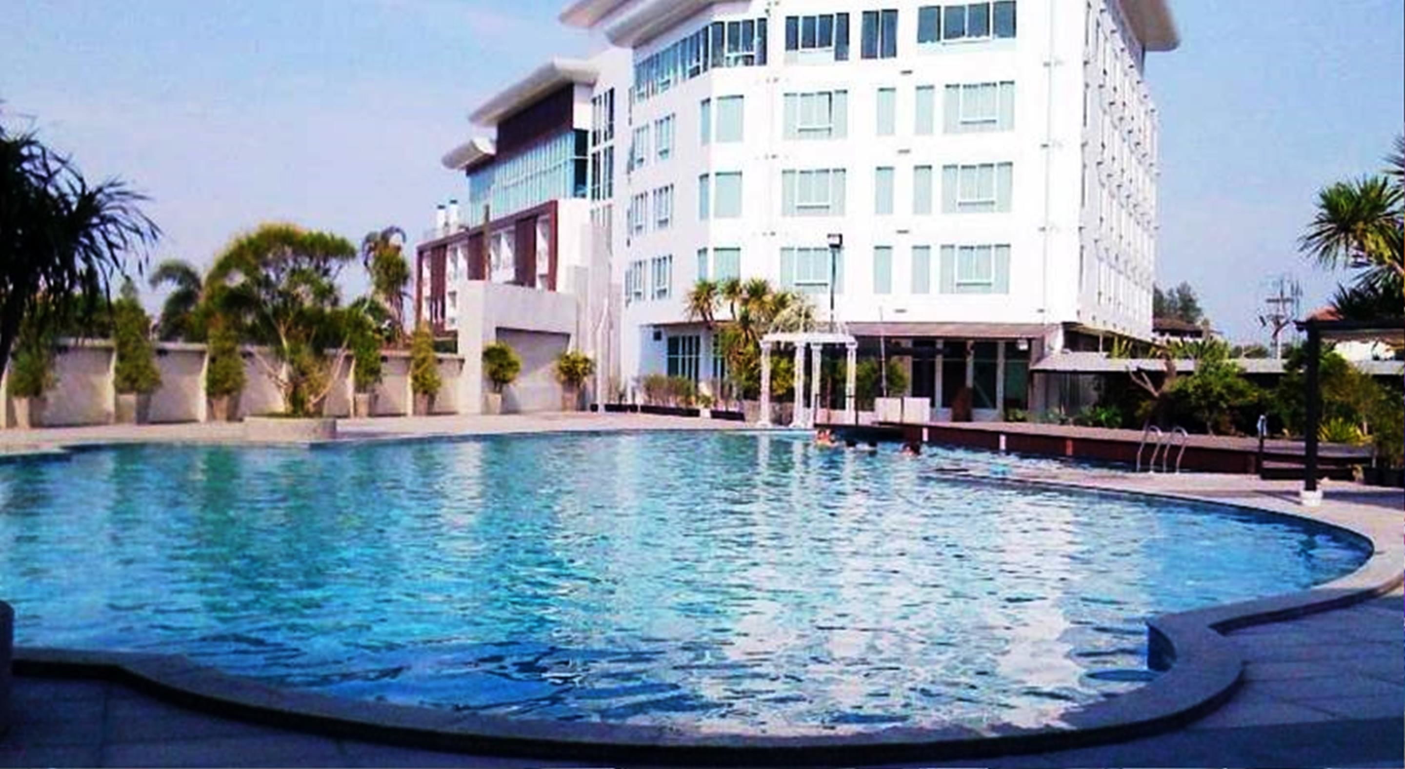 Piscina com um edifício moderno ao fundo.