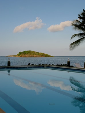 Een buitenzwembad, ligstoelen bij het zwembad