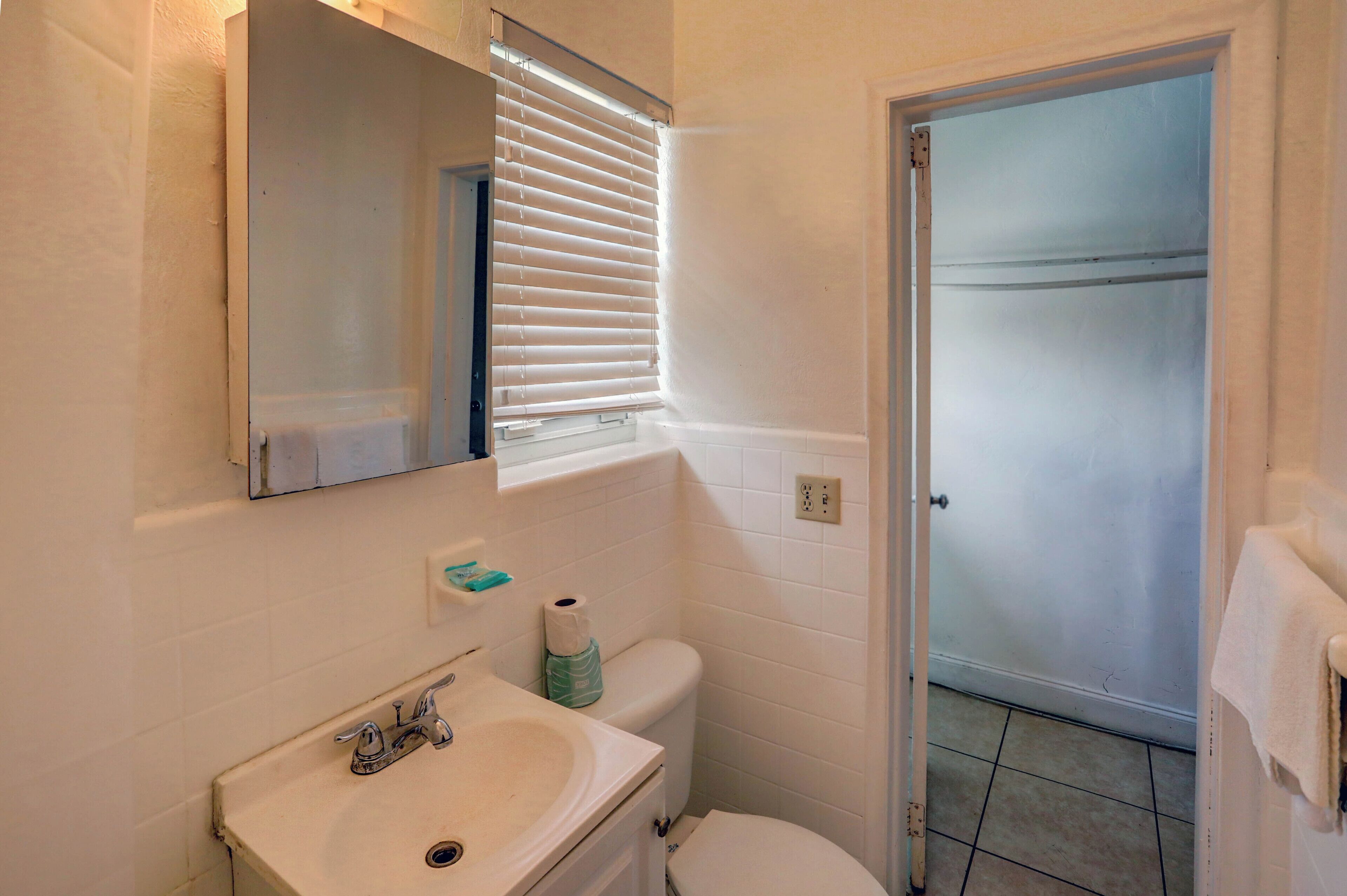A small bathroom with a sink, toilet, and a mirror above the sink.