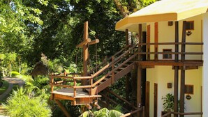A wooden staircase leading to a building surrounded by lush greenery. - Hotel Villa Maya (Flores)