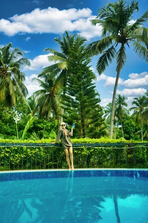 Piscine extérieure, parasols de plage, chaises longues