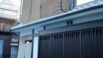 A building with a traditional facade, a wooden fence, and a metal gate.