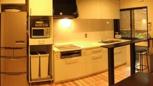 A compact kitchen with a built-in microwave, oven, and sink. - Kyoto Guesthouse Roujiya (Kyoto)