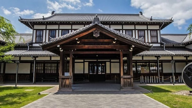 A traditional Japanese building with a wooden entrance pavilion, tiled roofs, and a stone pathway leading to the entrance. - Kyoto Guesthouse Roujiya (Kyoto)