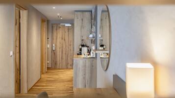 Ein moderner Hotelkorridor mit Holzboden, einem Spiegel und einer Rezeption mit Annehmlichkeiten.