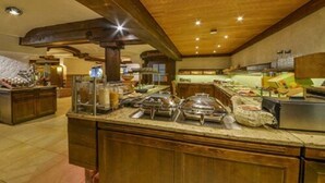 A buffet area with multiple food stations and a wooden ceiling. - Hotel Restaurant Waldsägmühle (Pfalzgrafenweiler)