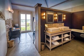 A modern bathroom with a large vanity, two sinks, and a bathtub.