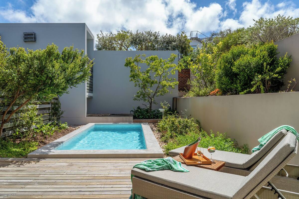 A swimming pool with lounge chairs and a wooden deck.