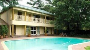 Un edificio de dos pisos con una piscina delantera.