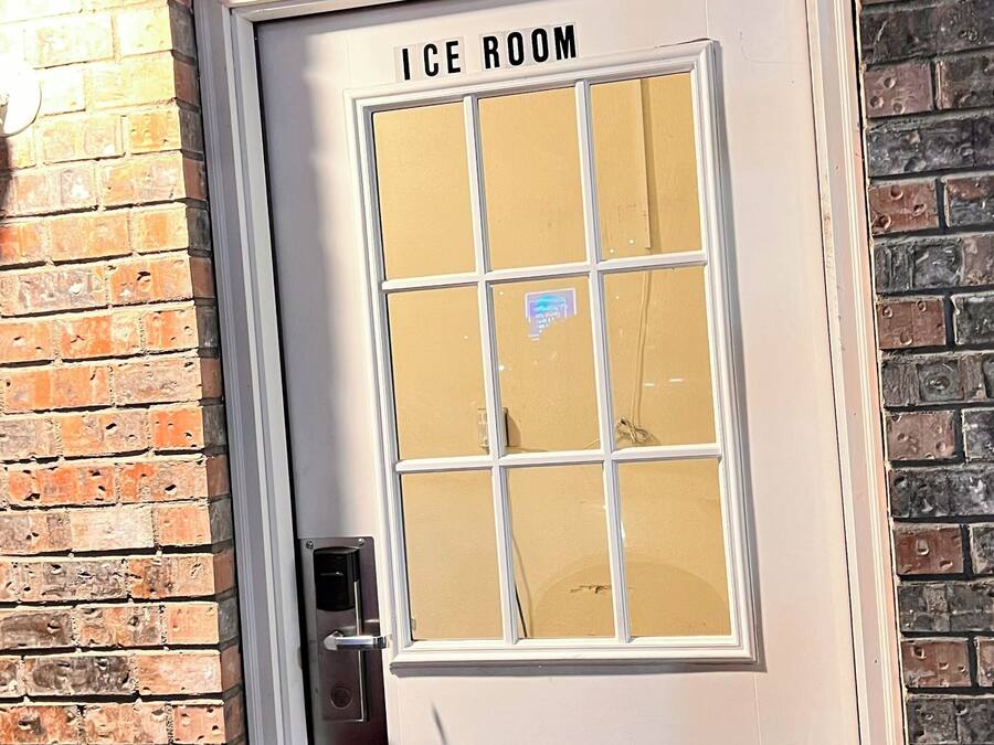 Une porte portant l’inscription « CHAMBRE FROIDE », avec un panneau en verre dépoli, une poignée en métal et un cadre blanc.