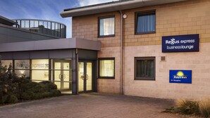 Een gebouw met een glazen ingang, borden met 'Regus Express business lounge' en 'Days Inn Reception'.