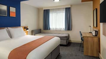 Une chambre d’hôtel avec un grand lit, un bureau, une chaise, un canapé et une fenêtre avec des rideaux.