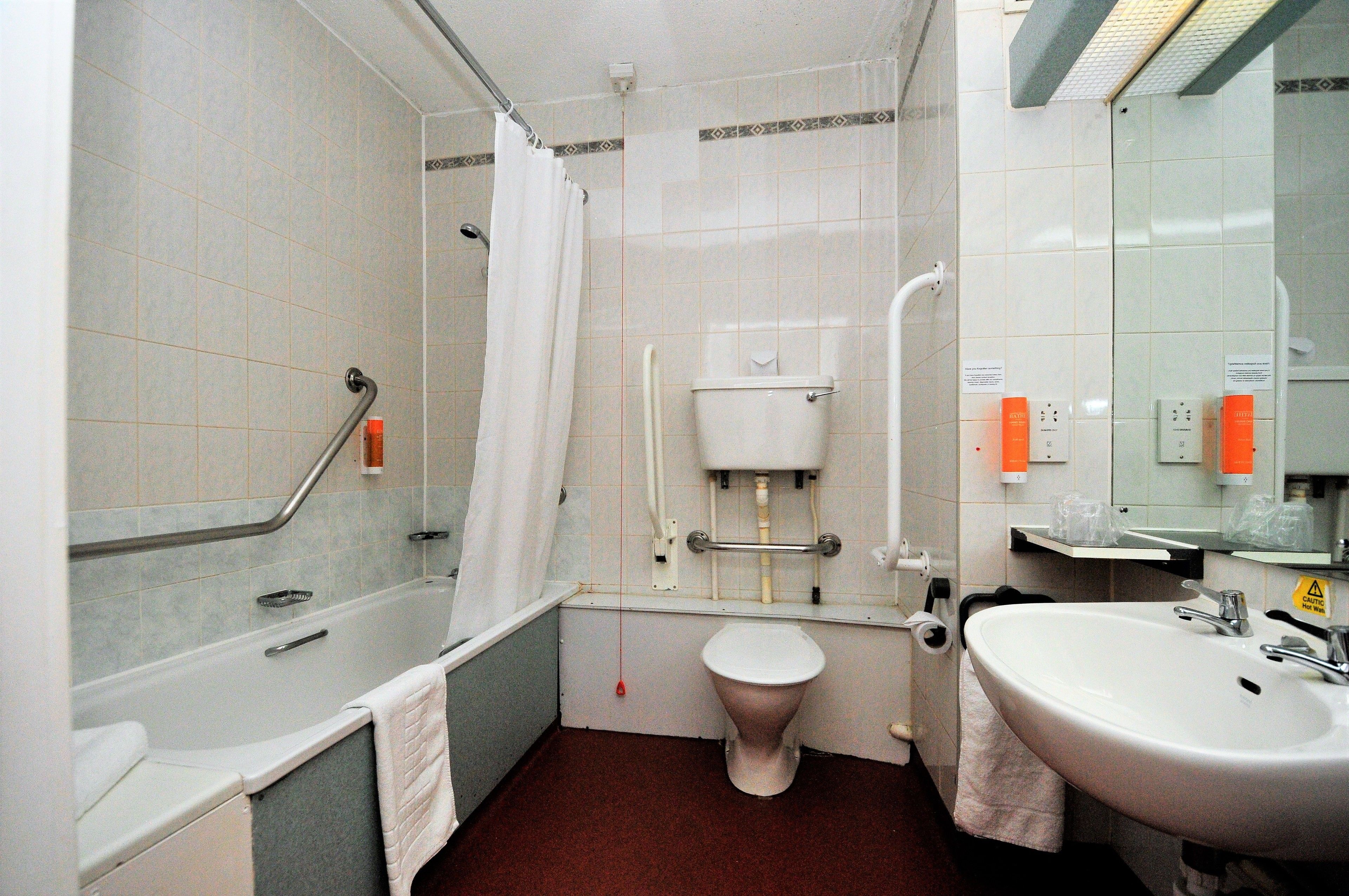Un baño con bañera, inodoro y lavamanos.