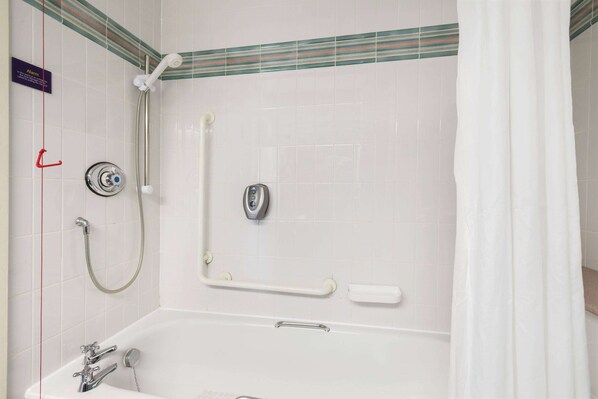 A bathroom with a bathtub, a shower, and a handrail. - Days Inn by Wyndham Lockerbie Annandale Water (Lockerbie)