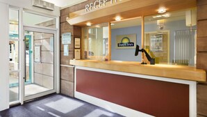 A reception area with a 'RECEPTION' sign, a Days Inn logo, and a 'FREE Wi-Fi' poster. - Days Inn by Wyndham Lockerbie Annandale Water (Lockerbie)