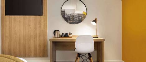 A modern room with a wooden desk, a white chair, a round mirror, and a blackboard.