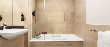 A modern bathroom with a sink, shower, and bathtub.