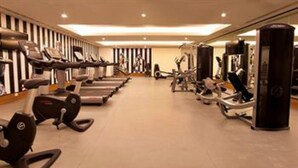 Ein Fitnessstudio mit Laufbändern, Crosstrainern und Gewichten.