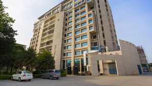 A multi-story building with a modern architectural design, featuring a series of balconies and large windows. - Ginger Chennai (Chennai)