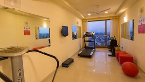 A gym with a treadmill, exercise bike, and red exercise balls. - Ginger Chennai (Chennai)