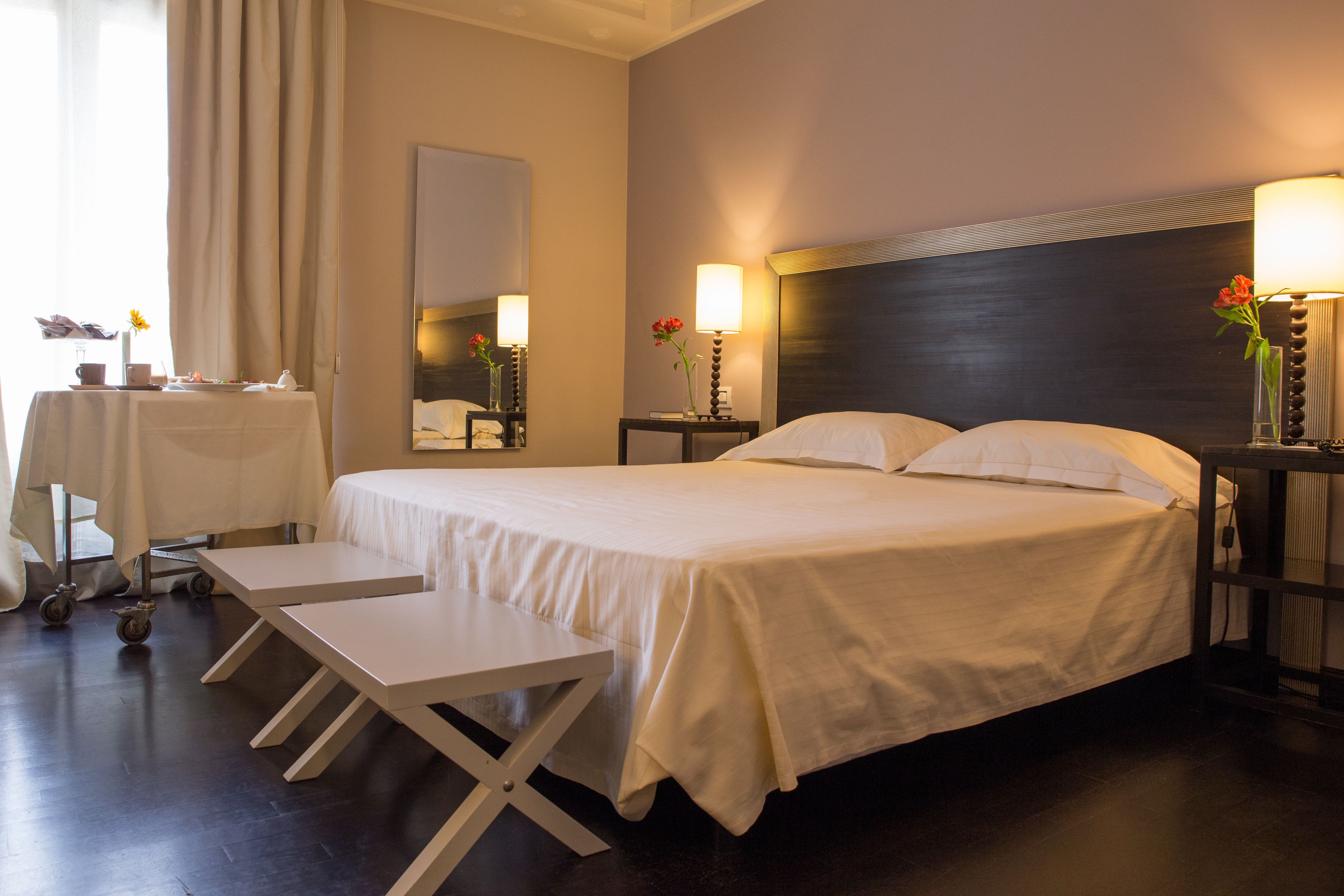 Una habitación de hotel con cama, mesitas de noche, escritorio y silla.