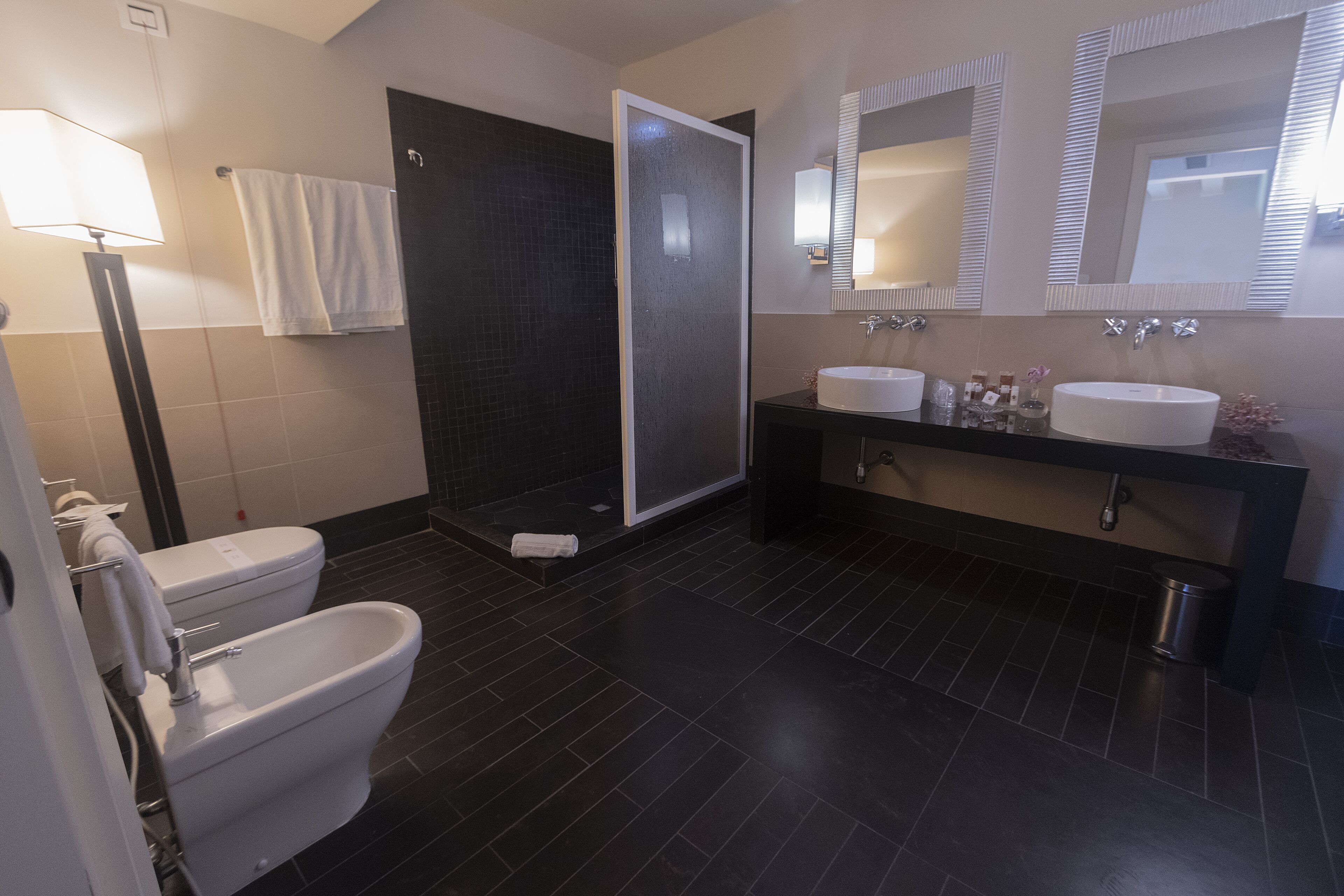 Ein modernes Badezimmer mit Toilette, Bidet und barrierefreier Dusche.