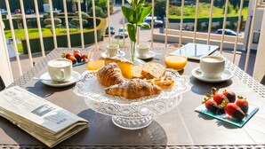 A balcony table with croissants, strawberries, coffee, and a newspaper. - Grand Hotel Villa Itria (Viagrande)