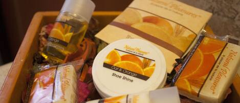 A wooden box containing various toiletries including a bottle of shampoo, a tube of lotion, and a bar of soap.