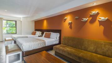 Habitación de hotel con dos camas, un sofá, una mesa de centro de madera y luces decorativas en la pared.