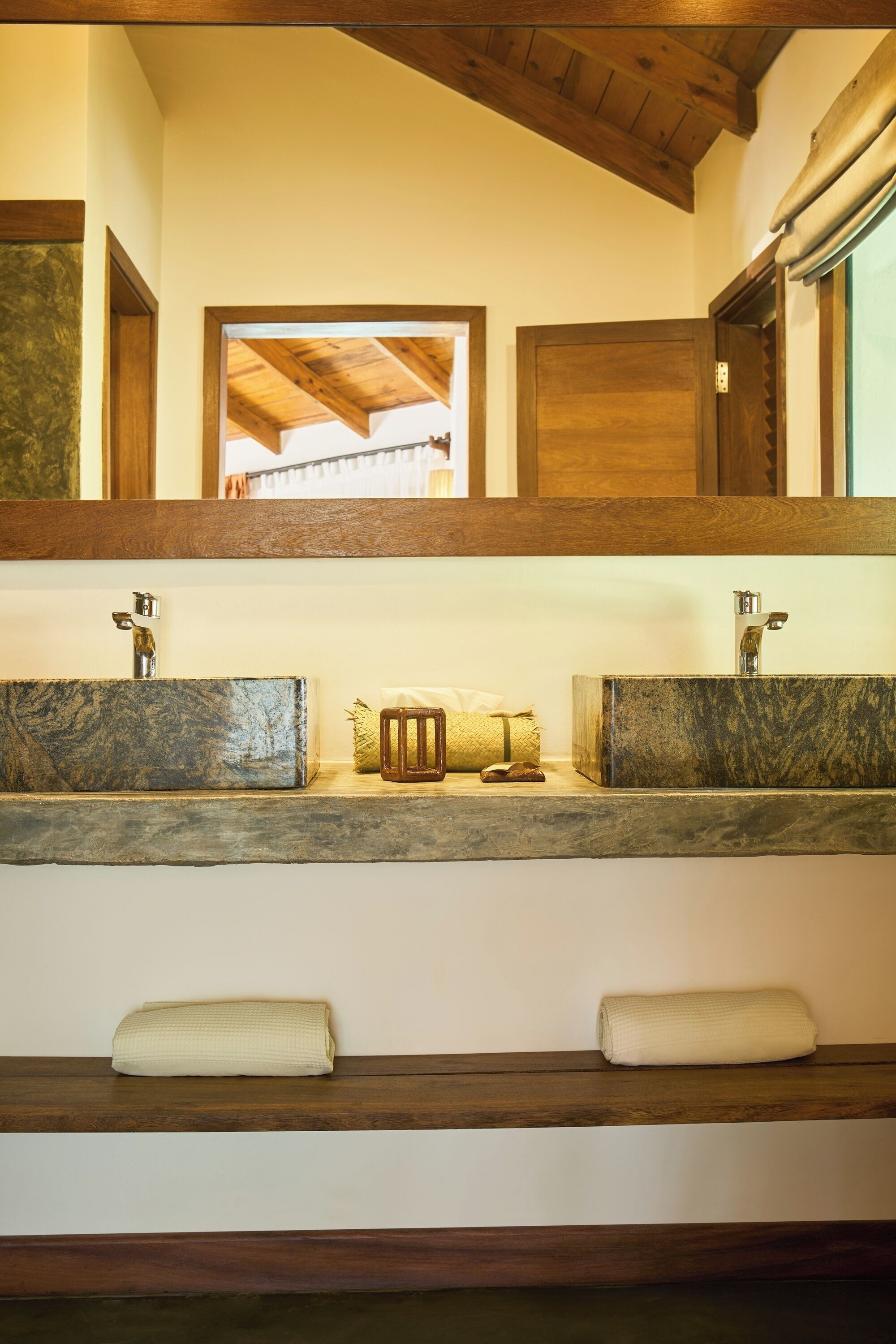 Une salle de bain avec deux lavabos, un miroir et un porte-serviettes.