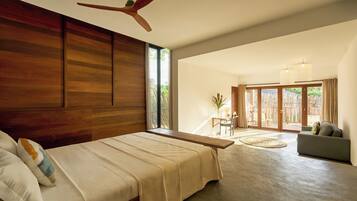 Une chambre spacieuse avec un grand lit, un ventilateur de plafond et une vue sur la terrasse extérieure.