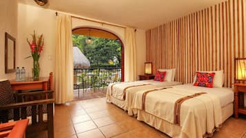 Une chambre d’hôtel avec deux lits, une table à manger, une chaise et une vue sur le jardin.