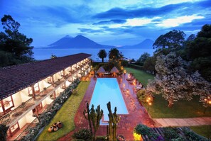 Ein Resort mit Schwimmbad, überdachter Terrasse und Blick auf Meer und Berge.