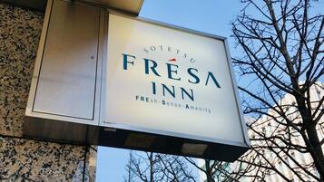 A sign for 'Sotetsu Fresna Inn' with a clear sky and leafless trees in the background.