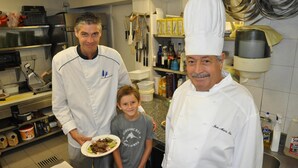Una cocina con electrodomésticos de acero inoxidable, un fregadero y diversos utensilios de cocina.