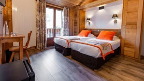 Un dormitorio de cabaña de madera con dos camas, una mesa de comedor y un refrigerador.